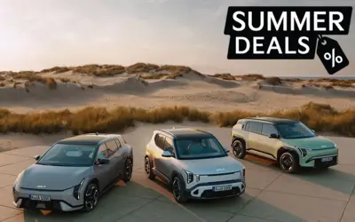 EV Modelle stehen auf einer Straße vor einer Düne. 