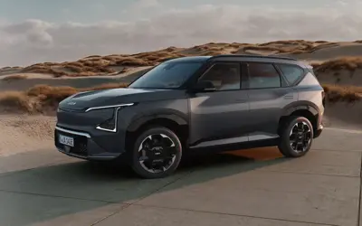 Kia EV5 steht vor einer Düne. 