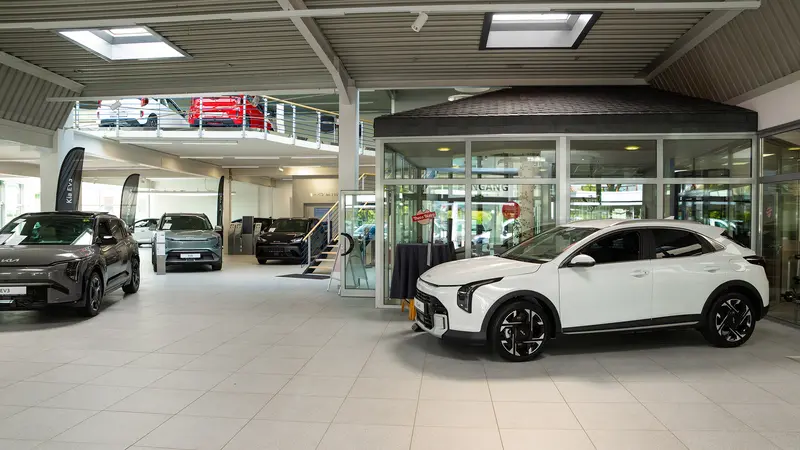 Innenansicht unserer modernen Autohauses mit mehreren ausgestellten Kia und BYD Fahrzeugen.